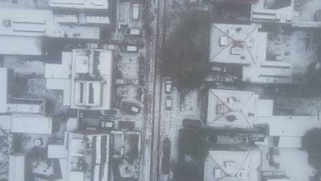 Top-down-view-of-snow-covered-street-in-suburban-neighborhood