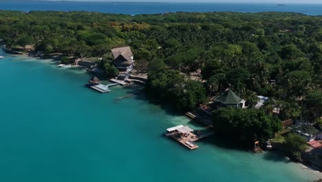 Drone-flying-over-small-hotel-in-Rosario-Island-with-small-boat