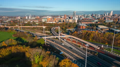 Hyperlapse-Motion-Timelapse-of-M621-Motorway-with-Leeds-City-Centre-in-Background-in-Autumn-flying-over-Block-of-Flats-Building-with-Busy-Traffic-on-Roads-West-Yorkshire-UK