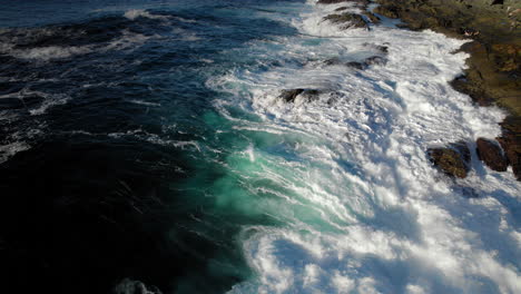 aerial-shot-of-ocean-waves-hitting-rocky-shore-crashing-violently