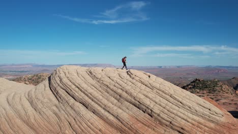 Aerial-View-of-Female-Hiker-With-Backpack-on-Top-of-Amazing-Rock-Formation