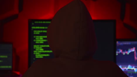 Anonymous-hacker-in-a-dark-room-with-multiple-monitors-writing-code