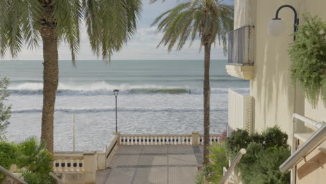 Urbanización-De-Playa-Junto-Al-Mar-Con-Surfistas-Montando-Olas-En-La-Distancia