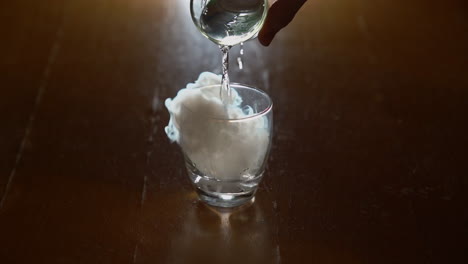A-man-pours-water-over-dry-ice-in-a-glass