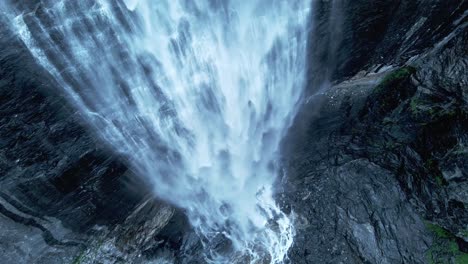 Luftaufnahmen-Von-Oben-Nach-Unten,-Die-Das-Fallende-Wasser-Eines-Wasserfalls-In-Einen-See-In-Norwegen-Zeigen---Spektakuläre-Kinoaufnahmen