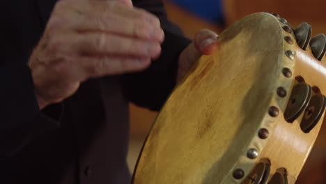 Close-up-man-playing-the-tambourine-percussion-instrument-in-orchestra