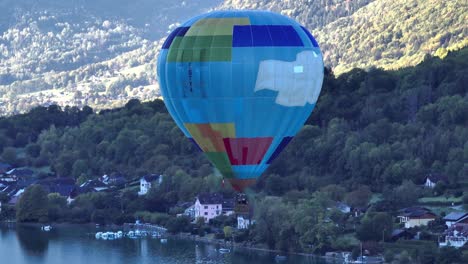 Hot-air-balloon-taking-off-by-the-lake-and-rising-up-above-the-mountains