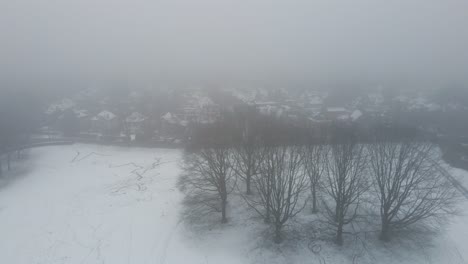 Antenne-Des-Schneebedeckten-Parks-Am-Rande-Eines-Vorortviertels-Im-Winter