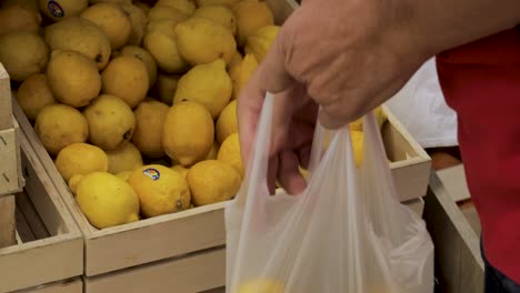 Man-picking-lemons-in-marketplace