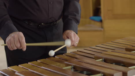 Close-up-man-in-smart-black-shirt-playing-xylophone-in-concert-hall