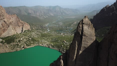 Rotating-revealing-cinematic-drone-shot-inside-the-Kel-Suu-lake-and-its-ravine's-rocks-in-Kyrgyzstan