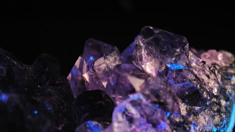 Leuchtender-Violetter-Amethyst-Kristall-Mit-Farbwechselnder-Beleuchtung-Vor-Schwarzem-Hintergrund