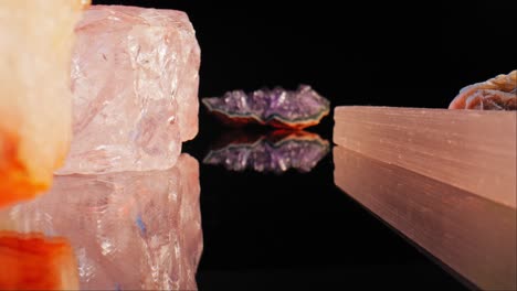 Zoom-Zwischen-Kristallen,-Mineralien-Und-Edelsteinen,-Reflexion-Darunter