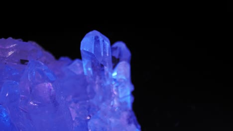 Quarz-Klarer-Kristall,-Der-In-Violettem-Licht-Vor-Schwarzem-Hintergrund-Schimmert