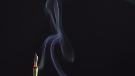 Palo-De-Incienso-Ardiente-Fumando-Sobre-Fondo-Negro-Oscuro-Simple,-Espacio-De-Copia-Macro