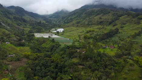 Die-Drohne-Fliegt-Durch-Eine-Landschaft-In-Kolumbien-Mit-Wolkenverhangenen-Bergen-Und-Kleinen-Feldern