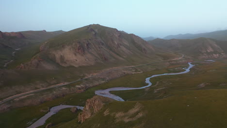 Rotating-cinematic-drone-shot-of-a-river-leading-into-the-Kel-Suu-lake-in-Kyrgyzstan