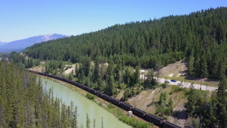 Aerial:-TransCanada-Highway,-railroad,-train-and-Bow-River-in-Canada