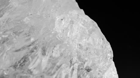 Clear-white-quartz-crystals-glistening-against-a-dark-background,-captured-through-smooth-motorized-slider-panning-and-macro-lens-for-intricate-details