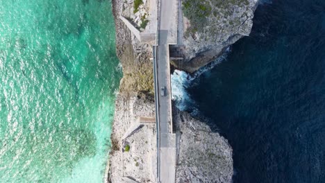 Cinematic-aerial-view-still-top-down-drone-shot-of-a-car-crossing-glass-window-bridge-on-the-island-of-eleuthera-in-the-bahamas---separating-the-atlantic-ocean-from-the-caribbean-sea