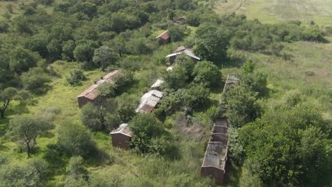 Drone-aerial-footage-of-an-Abandoned-farm-buildings-in-disrepair-over-grown-with-trees