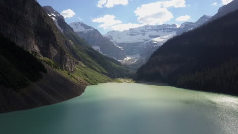 Low-flight-over-opaque-glacial-green-mountain-Lake-Louise,-Banff-Park