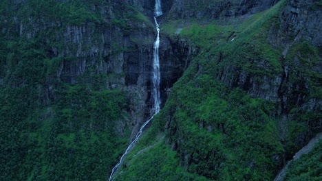 Tiro-De-Drone-Que-Muestra-Una-Cascada-Masiva-Entre-Montañas-Idílicas-En-Noruega