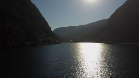 Bright-silver-sun-beam-on-dark-mountain-lake-at-Three-Valley-Gap,-BC