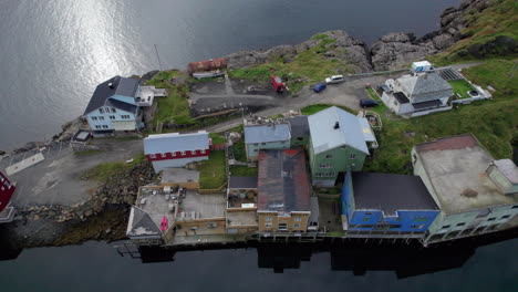 Aerial-Trucking-shot-of-the-Historical-Fishing-Village-Nyksund-with-birds-flying-from-the-buildings