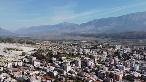 Aerial-view-of-village-in-Albania-with-mountain-range-in-background,-Europe