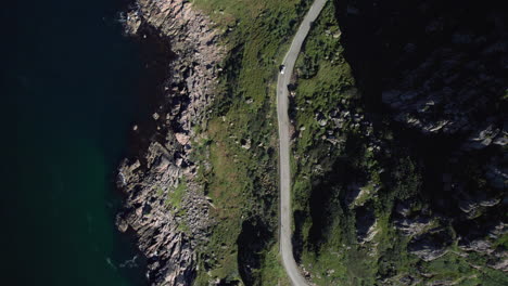 Aerial-birdseye-view-of-a-curvy-highway-along-the-rocky-coast-of-Norway-along-the-hillside