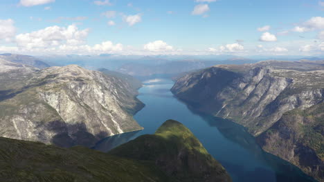 Wunderschöne-Drohnenaufnahme-Einer-Dramatischen-Fjordlandschaft-In-Norwegen-Mit-Steilen-Bergen-Und-Blauem-Wasser