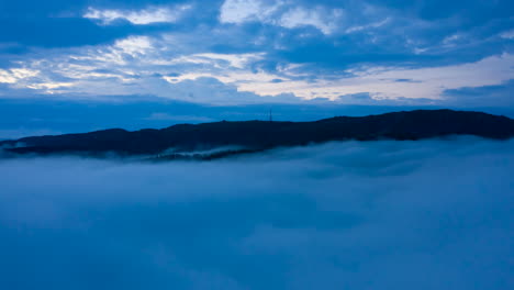 Drone-shot-of-moving-inversion-clouds-just-below-the-mountains