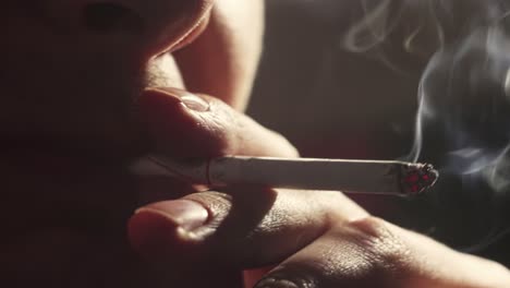 Close-up-of-unrecognizable-man-smoking-a-cigarette,-nicotine-addiction-concept,-selective-focus