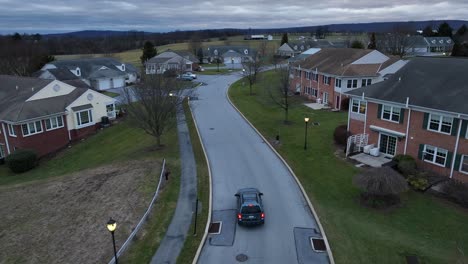 Aerial-tracking-shot-of-SUV-driving-through-retirement-neighborhood