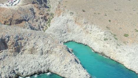Turquoise-Water-Of-Seitan-Limania-Beach-With-Rugged-Mountains-Near-Chania,-Crete-Island,-Greece