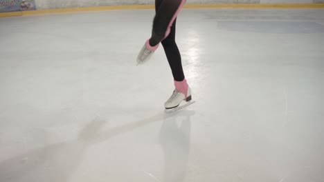 Unrecognizable-woman-doing-figure-skating-and-performing-spins-on-her-ice-skates,-waist-down-close-up
