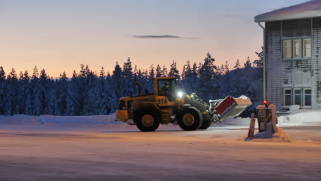 Airport-tractor,-snow-removal-from-apron-at-Arvidsjaur,-Sweden-at-dawn