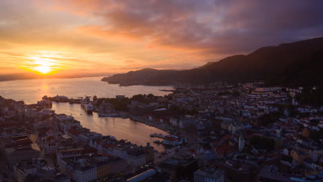 Drone-shot-flying-over-Bergen-towards-the-famous-landmark,-Bryggen,-in-a-beautiful-sunset