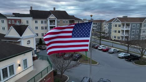Bandera-Estadounidense-Ondeando-Frente-A-Los-Edificios-De-La-Comunidad-De-Jubilados-En-América