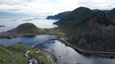 Revealing-the-stunning-landscape-surrounding-a-traditional-Norwegian-fishing-village,-Reverse-aerial-drone-shot