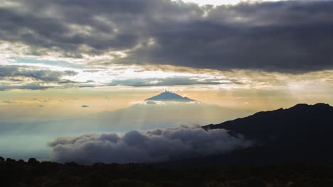 Amazing-sunset-with-rays-of-light-peaking-through-the-clouds-over-Mount-Meru,-seen-from-Shira-Camp-on-Mount-Kilimanjaro-in-Tanzania