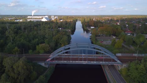 Ruhiger-Luftbildflug,-Der-Zur-Goldenen-Sommerstunde-2022-Langsam-Die-Drohnen-Eisenbahnbrücke-über-Den-Fluss-In-Brandenburg-Deutschland-Hinuntersinkt
