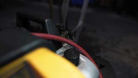 Mechaniker-Mit-Orangefarbenen-Handschuhen-Bindet-Kleine-Kappe-Ab