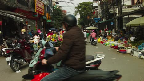 Static-shot-of-moped-riders-riding-through-the-busy-streets-of-Lang-Son,-Vietnam