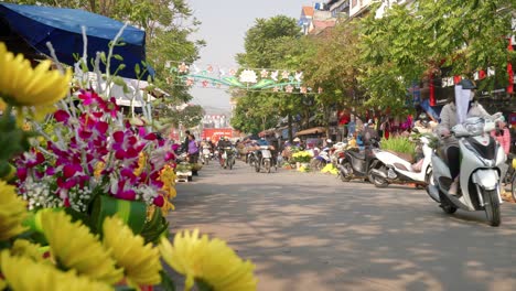 Low-static-shot-of-people-passing-by-the-vibrant-flowers-on-sale-at-the-Lang-Son-markets