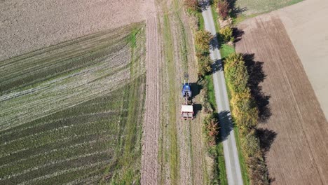 Stunning-aerial-view-flight-pursuit-flight-drone-of-a
tractor-on-fall-field-by-a-road-in-brandenburg-havelland-Germany-at-summer-2022