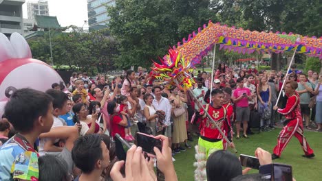Group-of-spectators-watching-a-Dragon-dance-performance-happily-celebrating-Chinese-New-Year-in-Sun-Yat-Sen-Nanyang-Memorial-Hall,-also-known-as-Wan-Qing-Yuan,-Singapore
