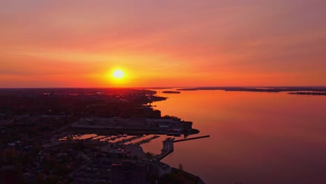 Aerial-orange-sky-sunrise-over-a-city-waterfront