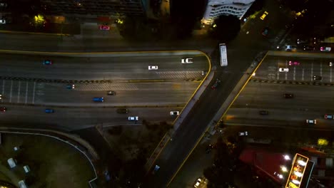 Overhead-aerial-view-of-a-main-avenue-with-high-traffic-at-night-in-Mexico-City,-slow-motion